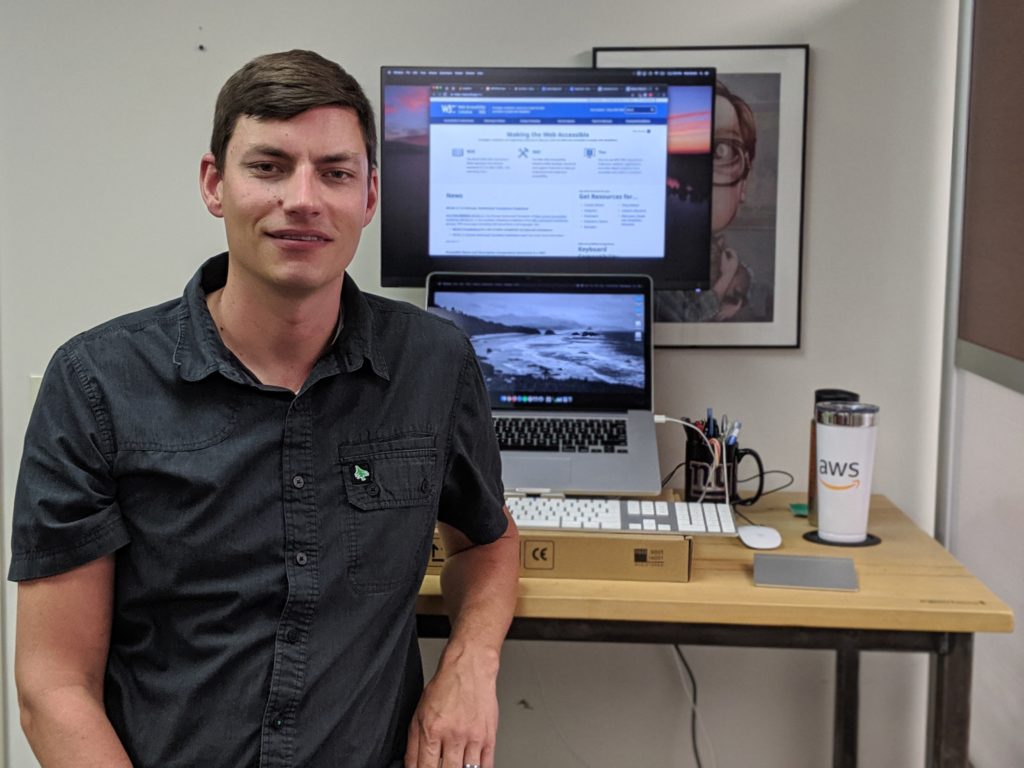 Photo of Pete Bruhn sitting in front of his new desk.