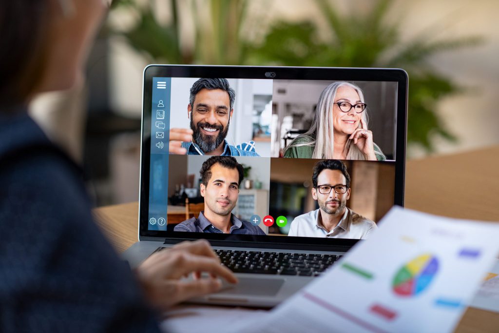 A person looking at a laptop computer with four other people in a video chat