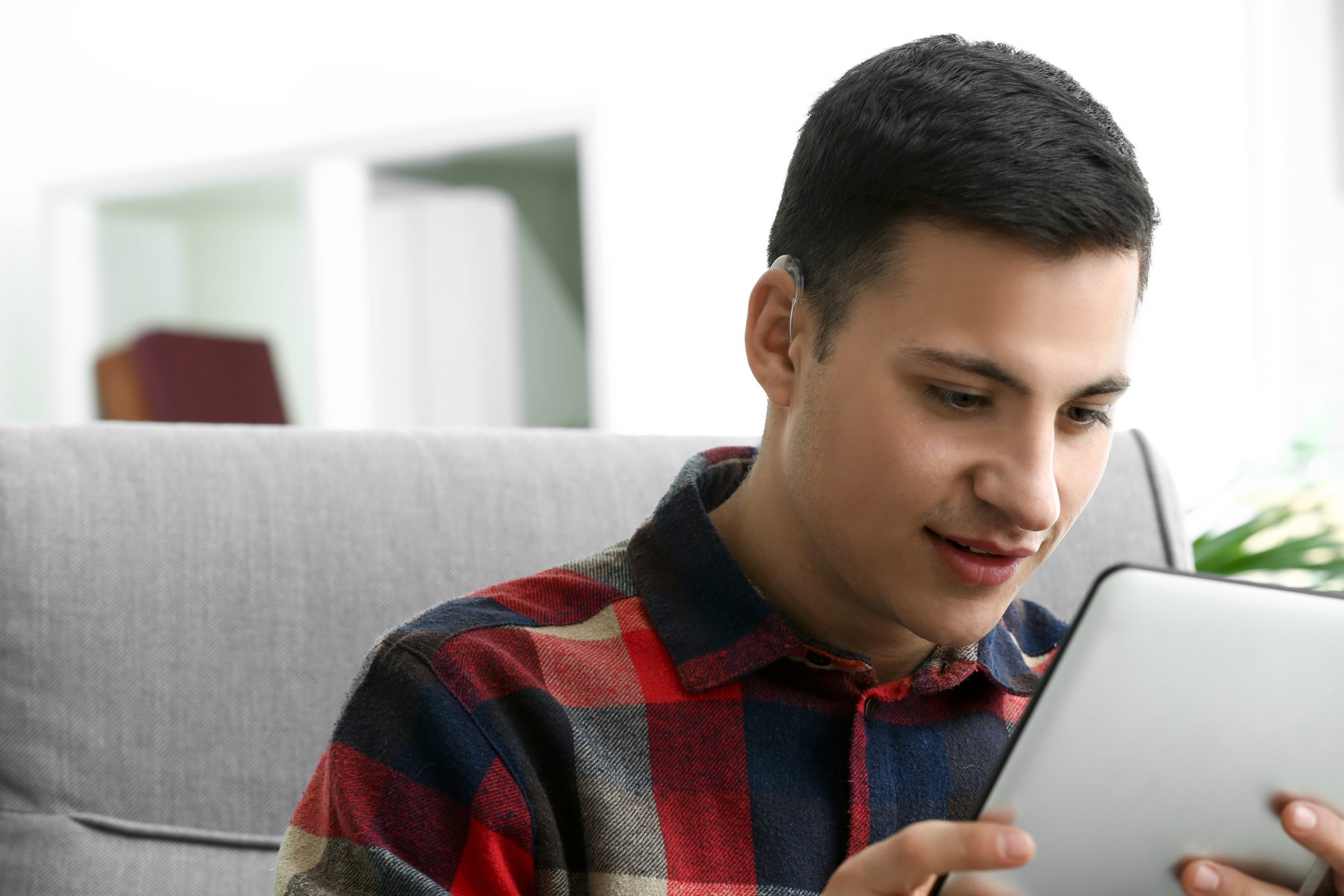 Person with a hearing aid looking at a tablet