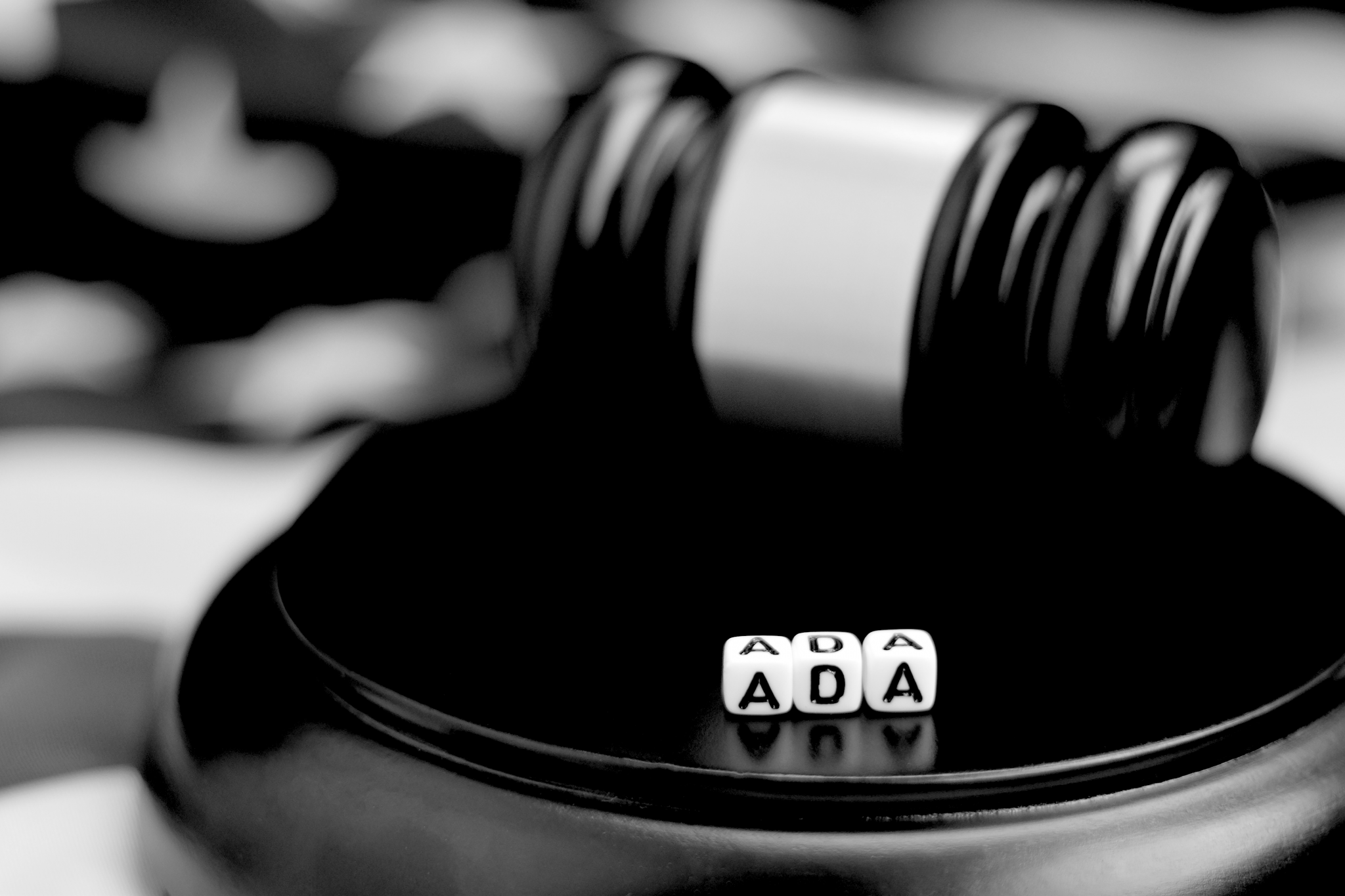 A judge's mallet with the letters ADA spelled out in dice in front of it