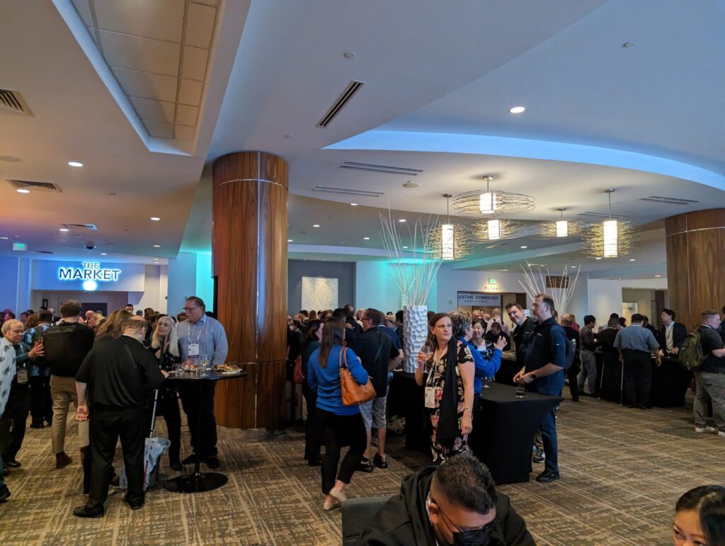 Large conference crowd conversing in the lobby.