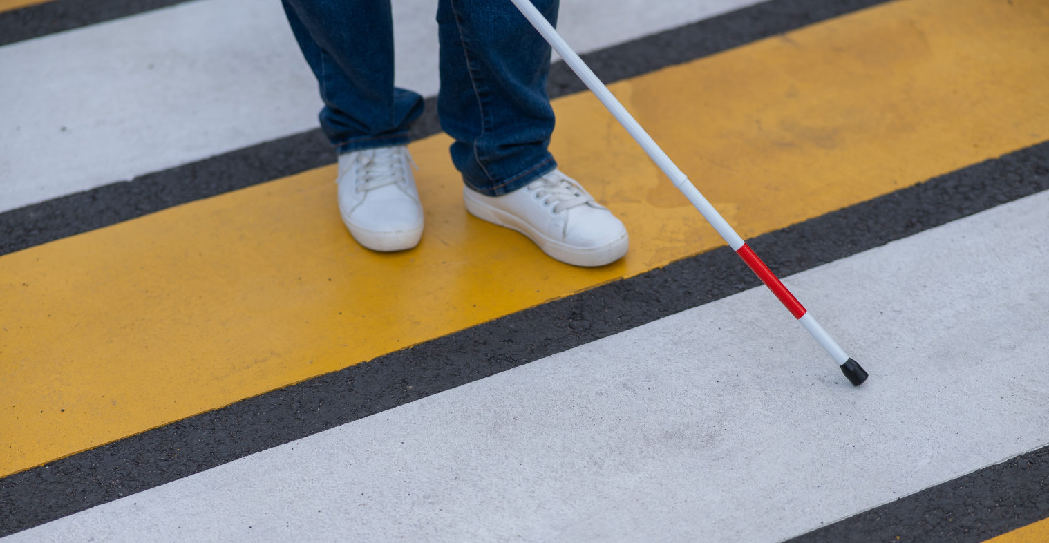 Crosswalk with person walking across using a cane